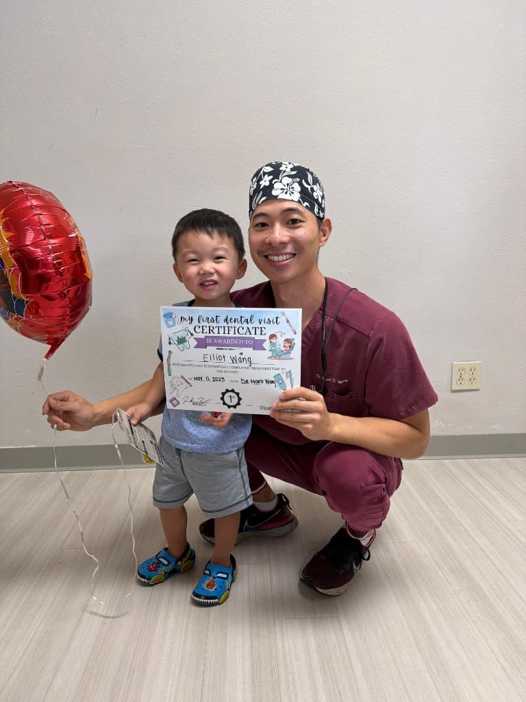Dr. Mark Wang interacting warmly with a young child patient, demonstrating our gentle approach to pediatric dentistry
